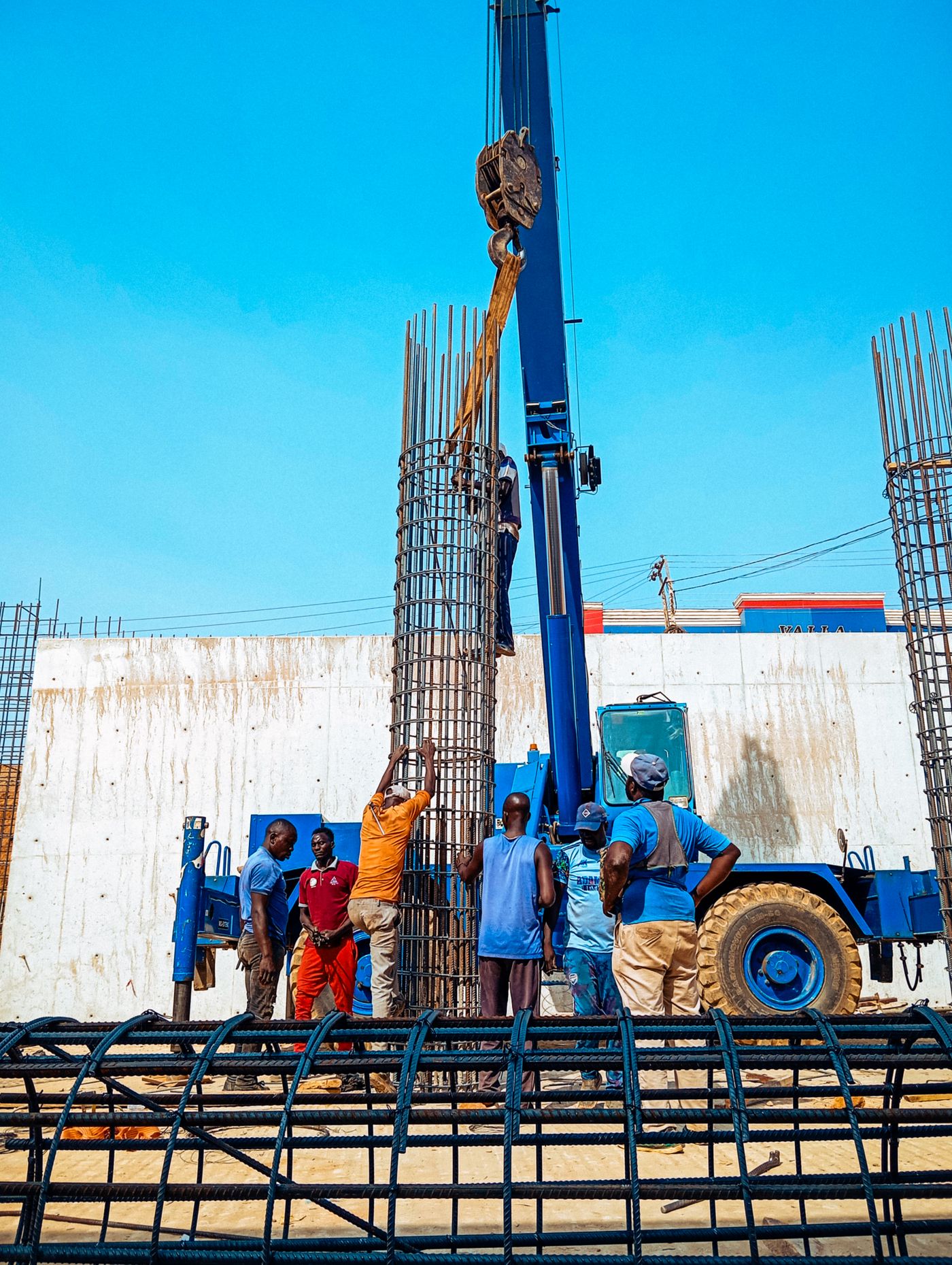 Workers erecting a reinforced column on a construction site