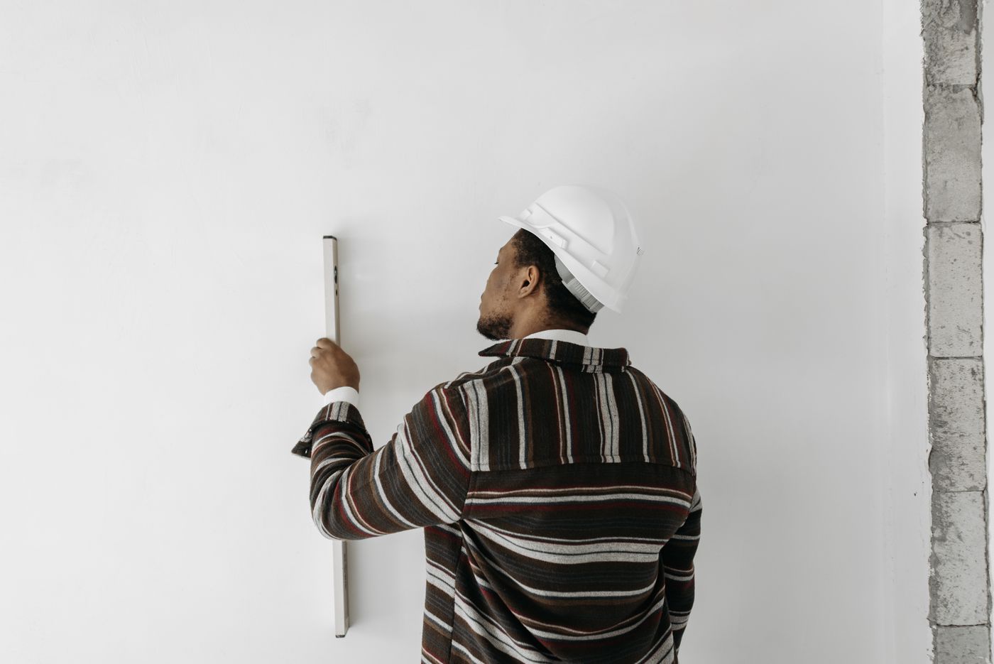 Worker checking a wall with a spirit level during a renovation